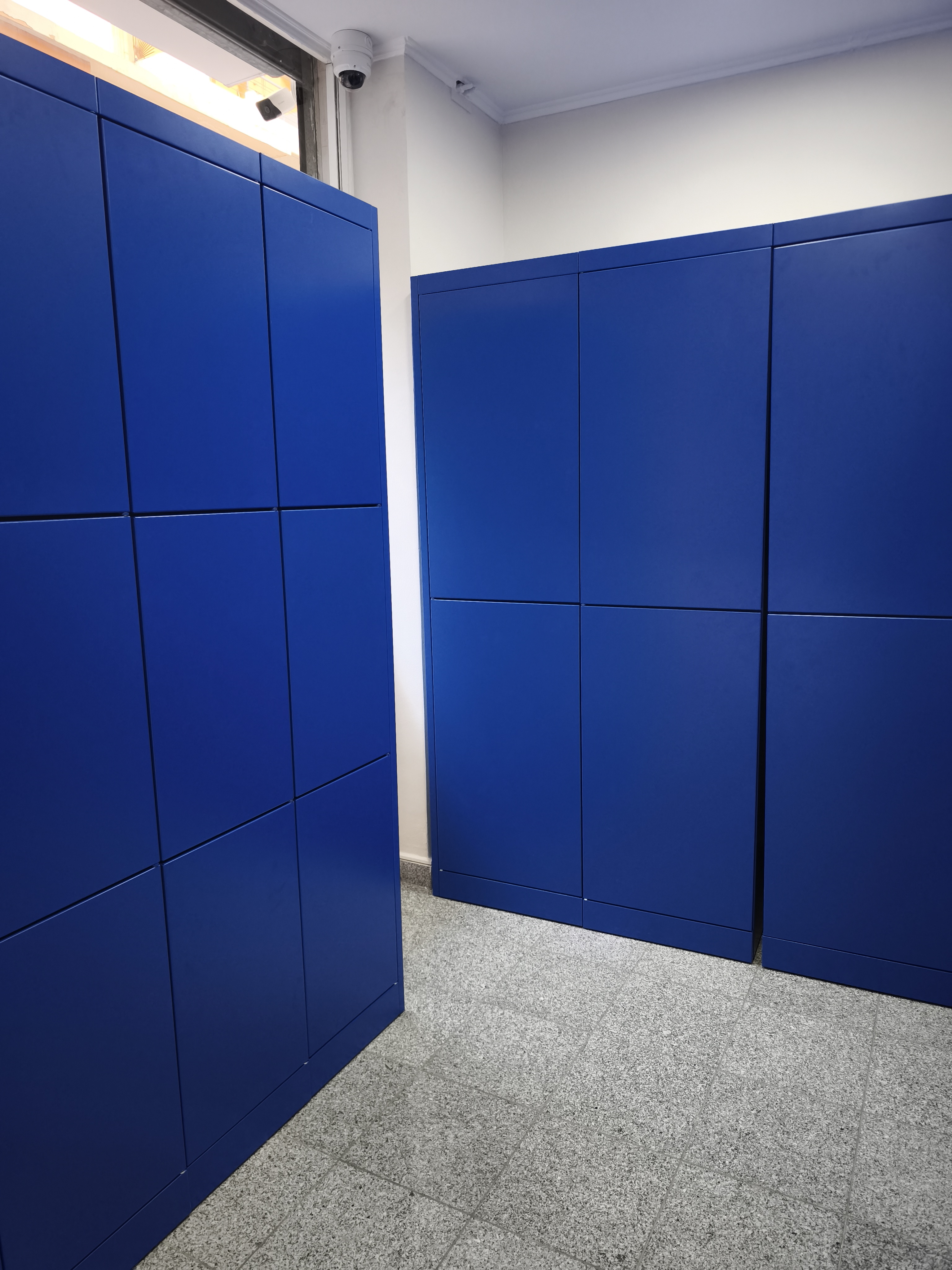 Rows of secure automated lockers with digital access panels in an Athens transit hub