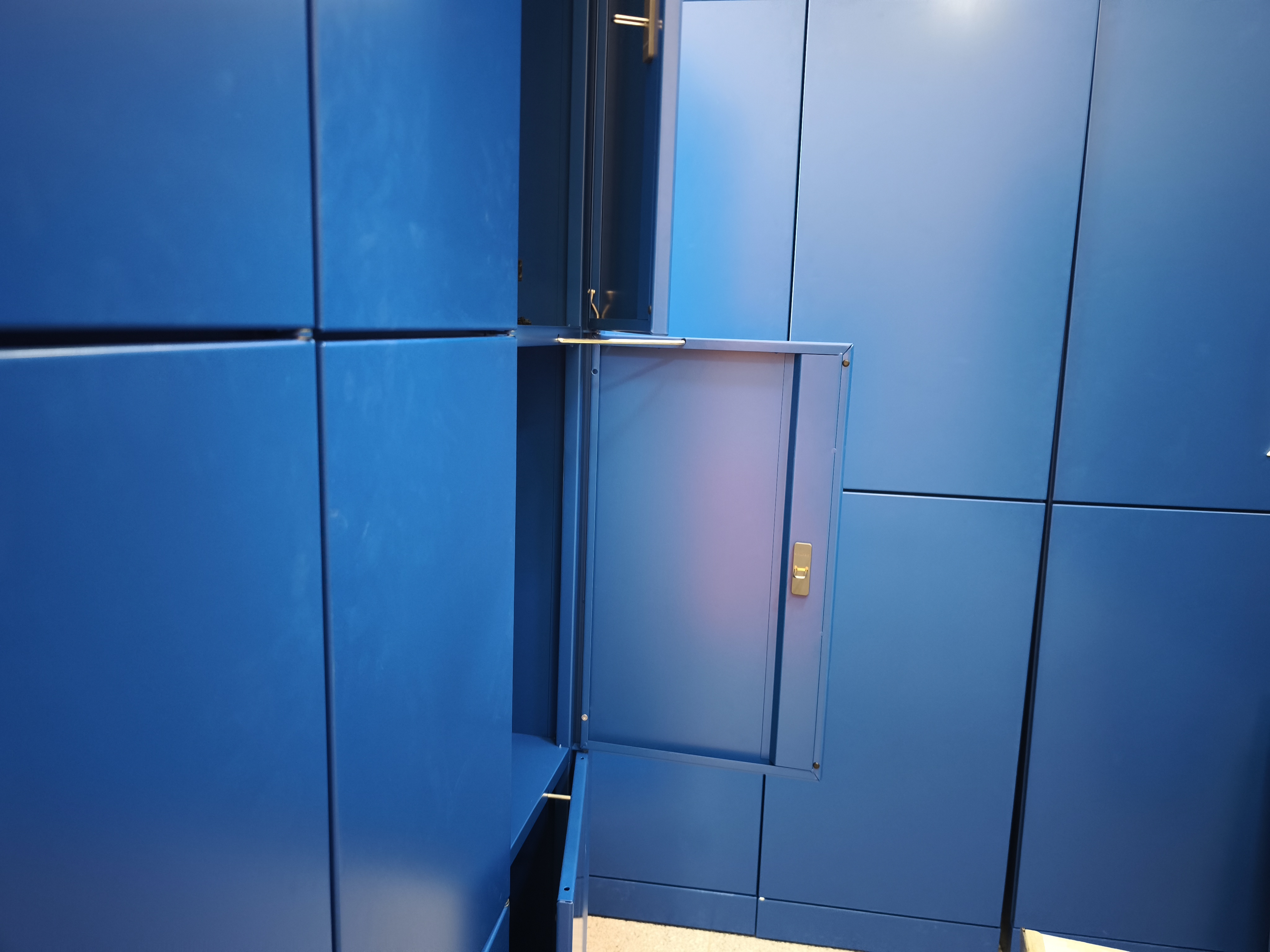 Open blue locker compartment in a bank of automated lockers